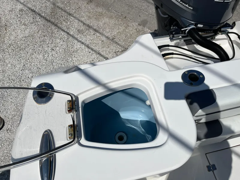 Slide: The Image of 2018 Tidewater 232 CC Adventure boat with open livewell and visible engine components. - 5