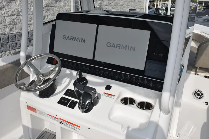 Slide: The Image of 2025 Sea Hunt Ultra 305 SE boat dashboard with dual Garmin displays and steering wheel. - 10