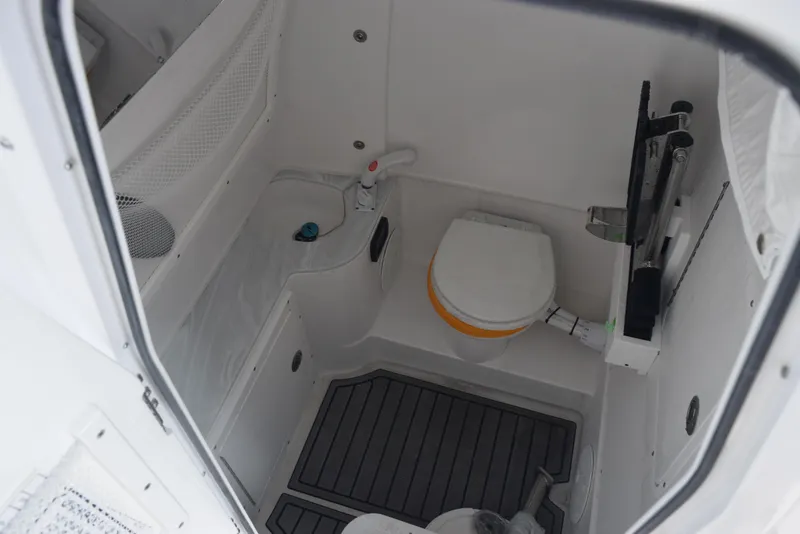 Slide: The Image of 2025 Sea Hunt Ultra 305 SE boat interior with compact marine toilet and storage. - 14
