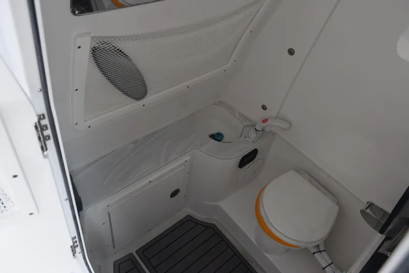Slide: The Image of Interior of 2025 Sea Hunt Ultra 305 SE boat bathroom with toilet and storage. - 15