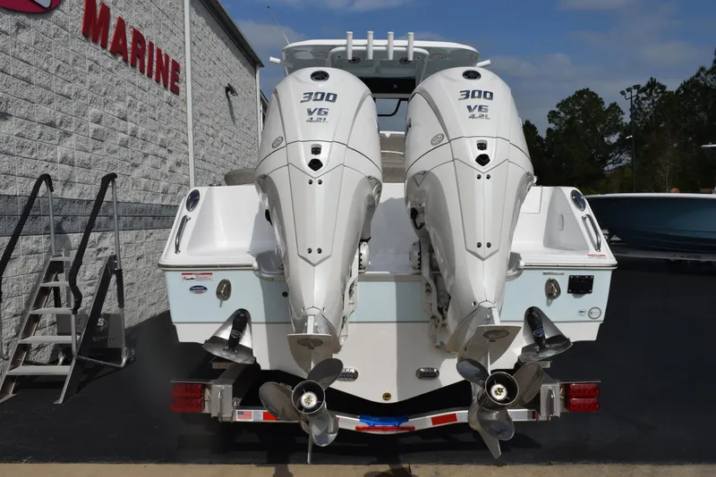 Slide: The Image of 2025 Sea Hunt Ultra 305 SE with twin 300 V6 engines, rear view at a marine dealership. - 5
