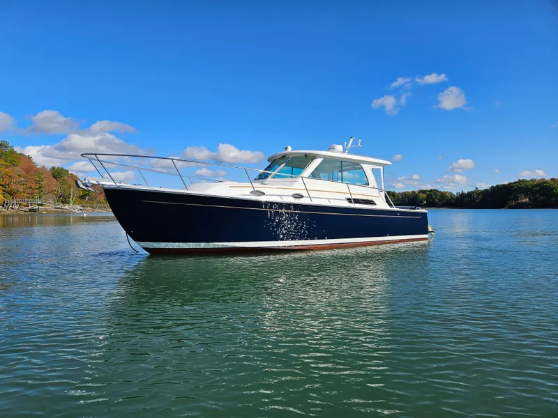 Slide: The Image of 2008 Back Cove 33 Express boat on calm water under clear blue sky. - 2