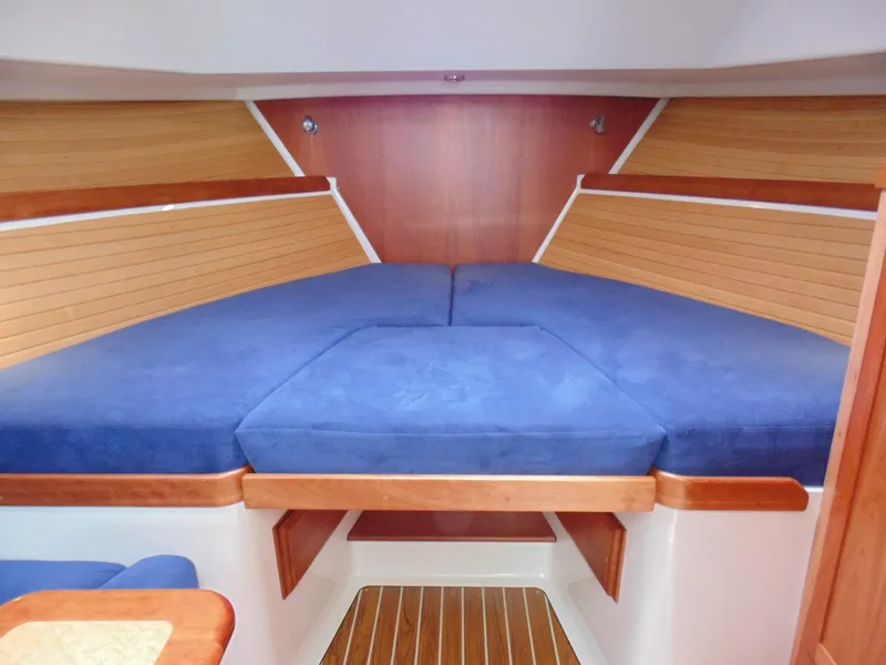 Slide: The Image of 2008 Back Cove 33 Express cabin with blue cushions and wooden interior. - 24