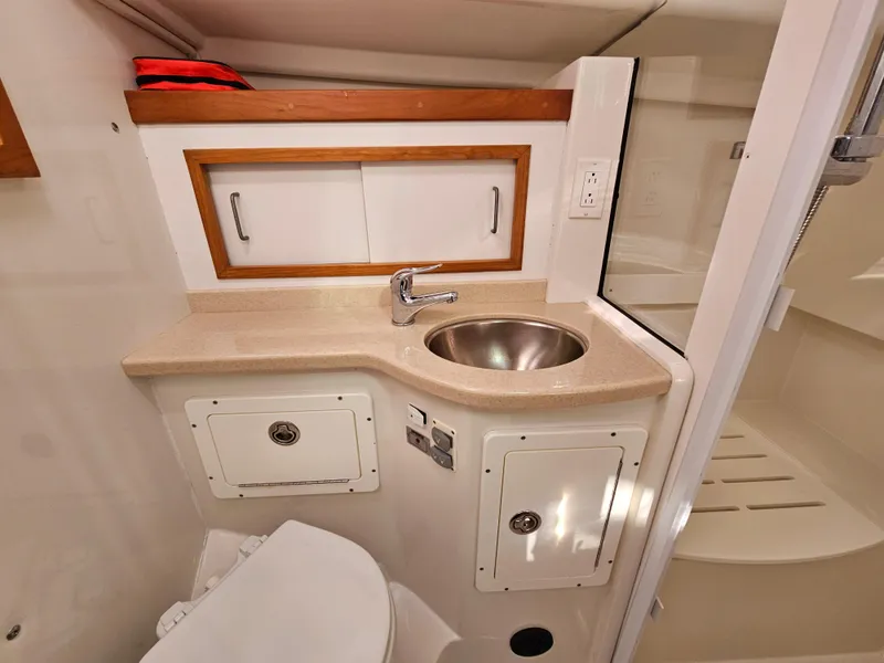 Slide: The Image of 2008 Back Cove 33 Express bathroom with sink, storage cabinets, and shower area. - 46