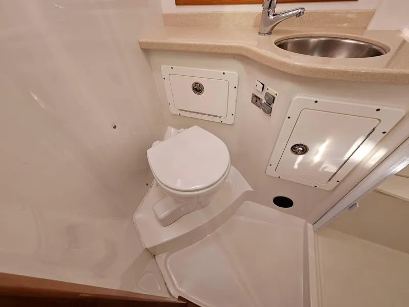 Slide: The Image of 2008 Back Cove 33 Express bathroom with toilet, sink, and storage compartments. - 48