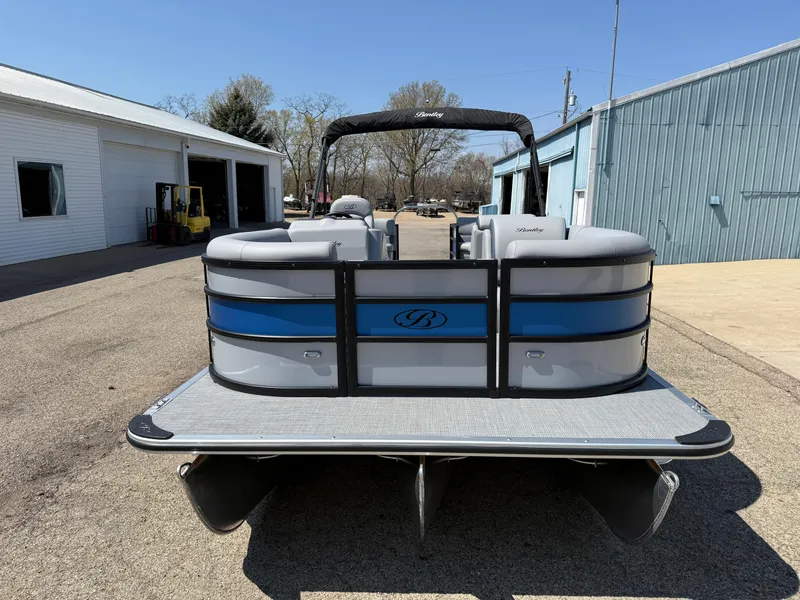 Slide: The Image of 2025 Bentley Pontoons Bolt 223 pontoon boat, rear view, parked outdoors. - 2
