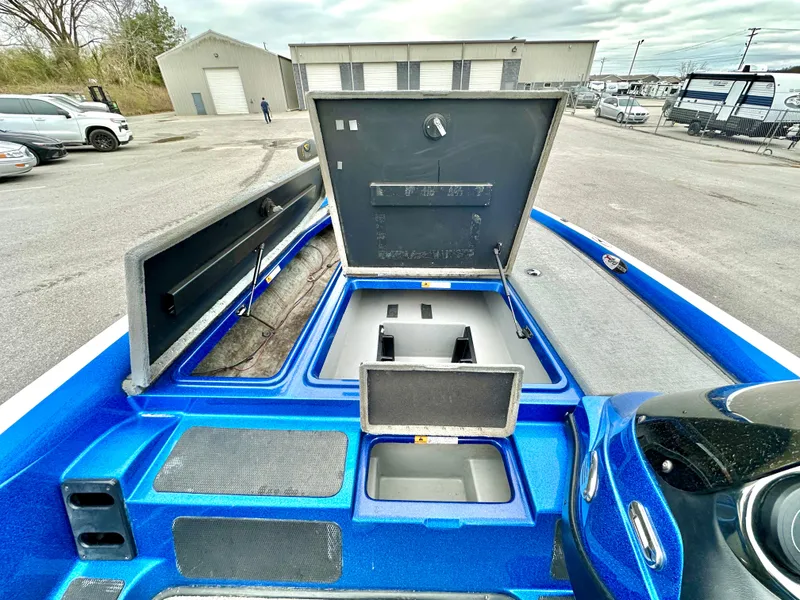 Slide: The Image of 2009 Stratos 294 XL Evolution boat interior with open storage compartments in a parking lot. - 15