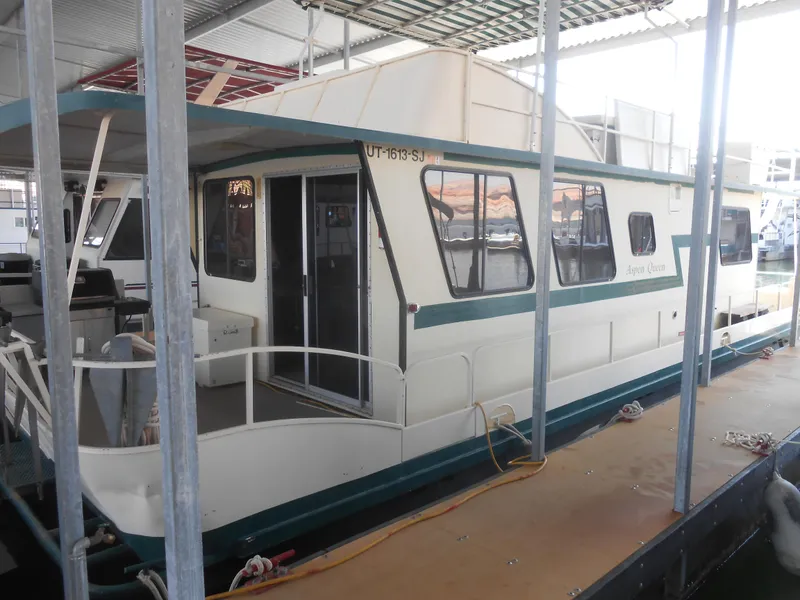 Slide: The Image of 1984 Boatel Hercules houseboat docked in a covered marina. - 10