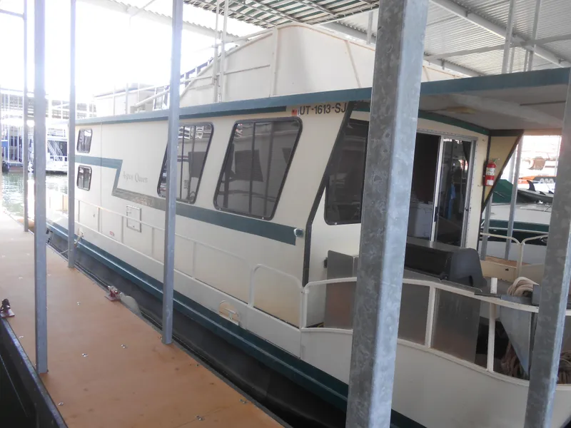 Slide: The Image of 1984 Boatel Hercules houseboat docked in a covered marina. - 11