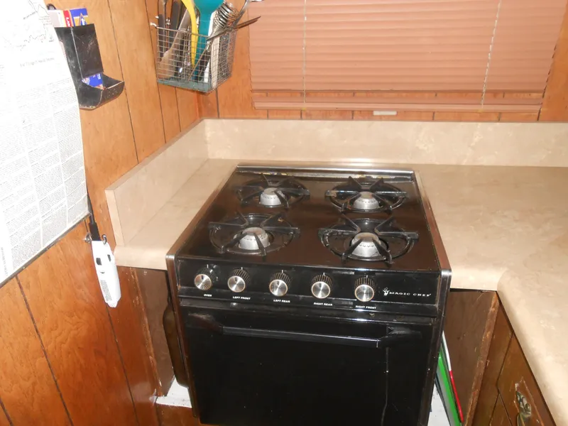 Slide: The Image of 1984 Boatel Hercules kitchen with a four-burner stove and wooden cabinetry. - 15