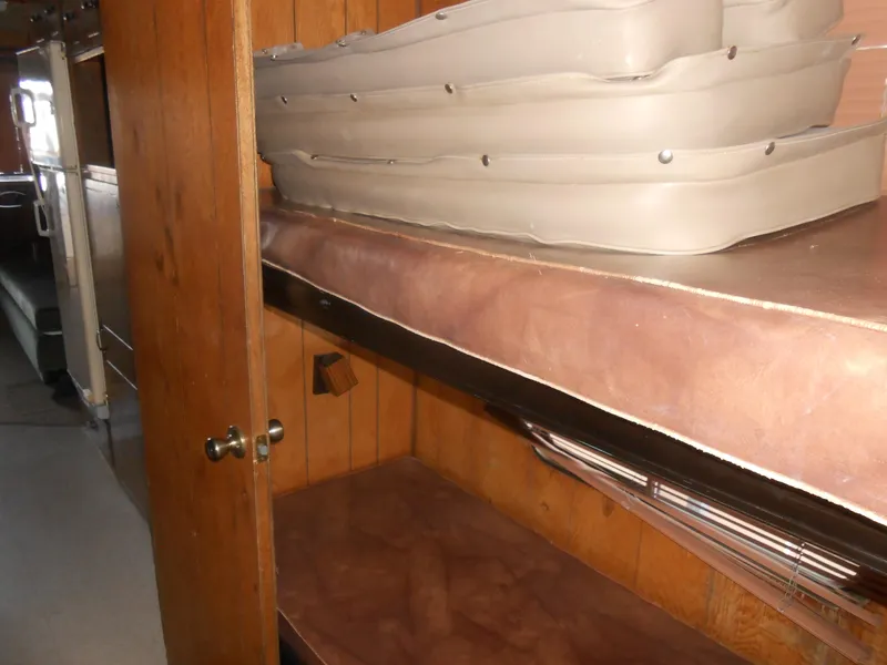 Slide: The Image of Interior of 1984 Boatel Hercules with wooden paneling and stacked cushions. - 18