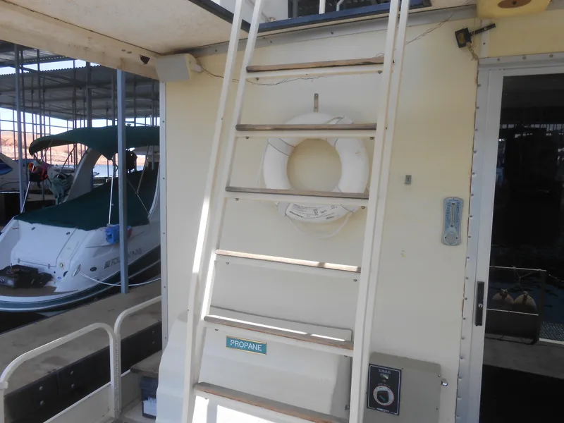 Slide: The Image of 1984 Boatel Hercules boat with ladder, life preserver, and propane sign in marina setting. - 19