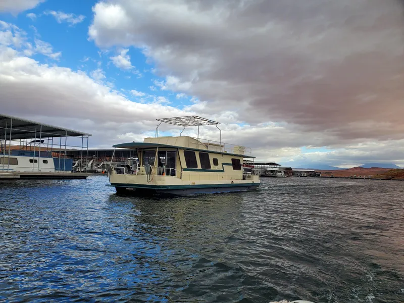 Slide: The Image of 1984 Boatel Hercules houseboat on a lake under a partly cloudy sky. - 2