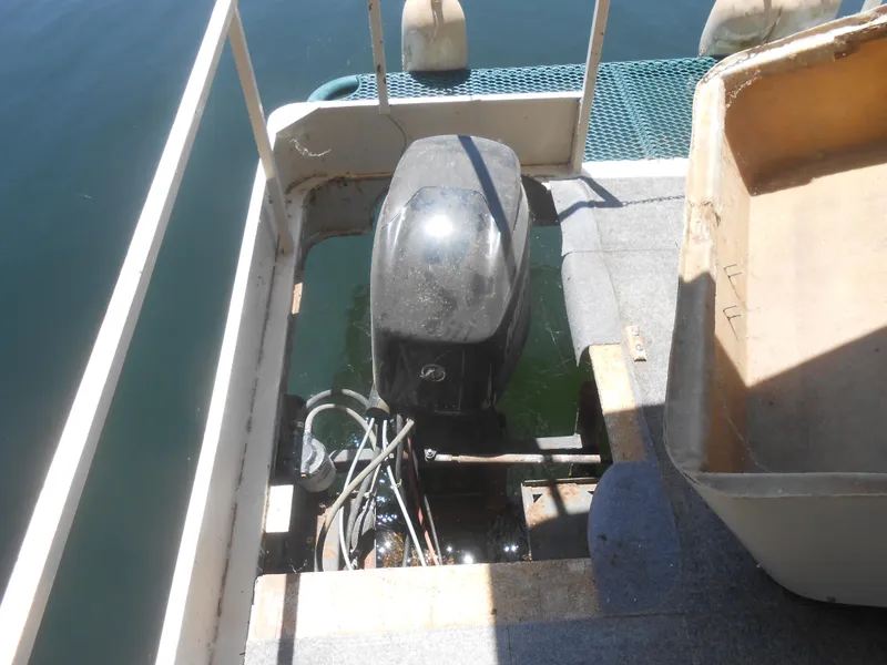 Slide: The Image of Outboard motor on 1984 Boatel Hercules boat, docked on calm water. - 20