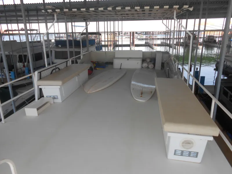 Slide: The Image of 1984 Boatel Hercules houseboat deck with surfboards under covered marina. - 22