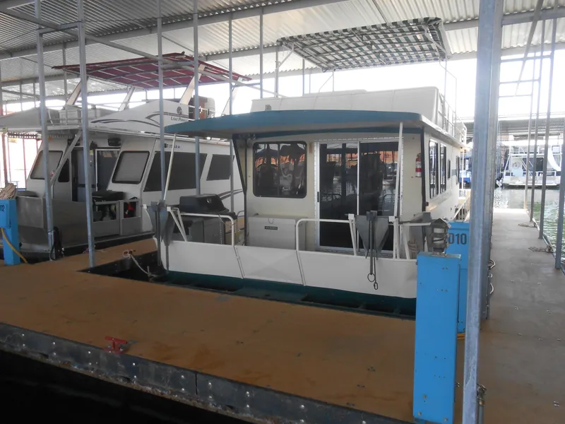 Slide: The Image of 1984 Boatel Hercules houseboat docked in a covered marina. - 24