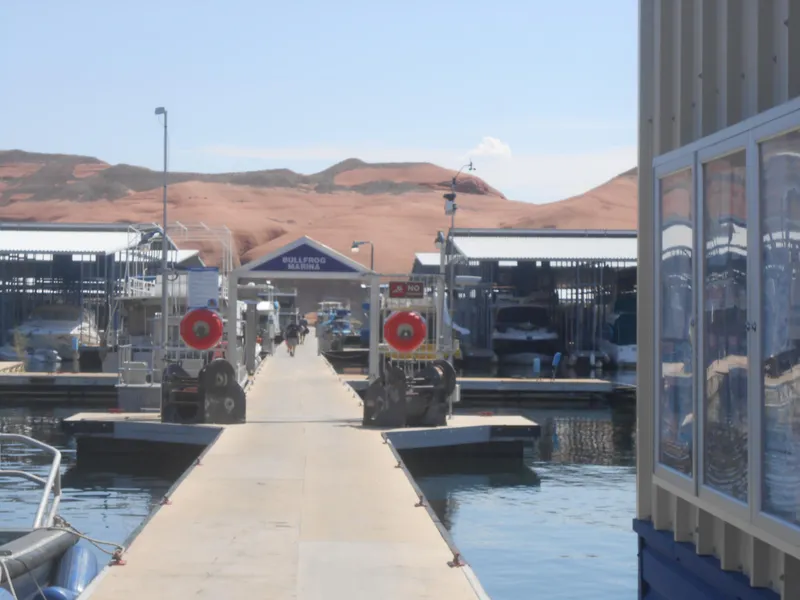 Slide: The Image of Bullfrog Marina dock with boats, featuring Boatel Hercules, 1984 model, under clear blue sky. - 25