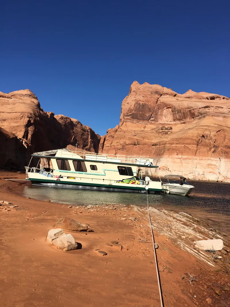 Slide: The Image of 1984 Boatel Hercules houseboat moored on a sandy shore with rocky cliffs in the background. - 3