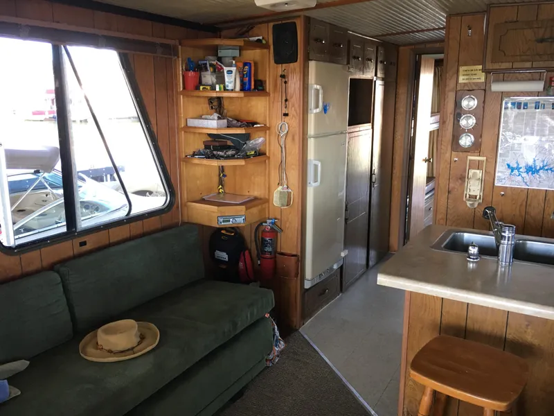 Slide: The Image of Interior of a 1984 Boatel Hercules houseboat with cozy seating and kitchen area. - 6