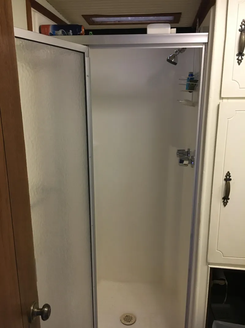 Slide: The Image of 1984 Boatel Hercules shower interior with white walls and metal fixtures. - 9