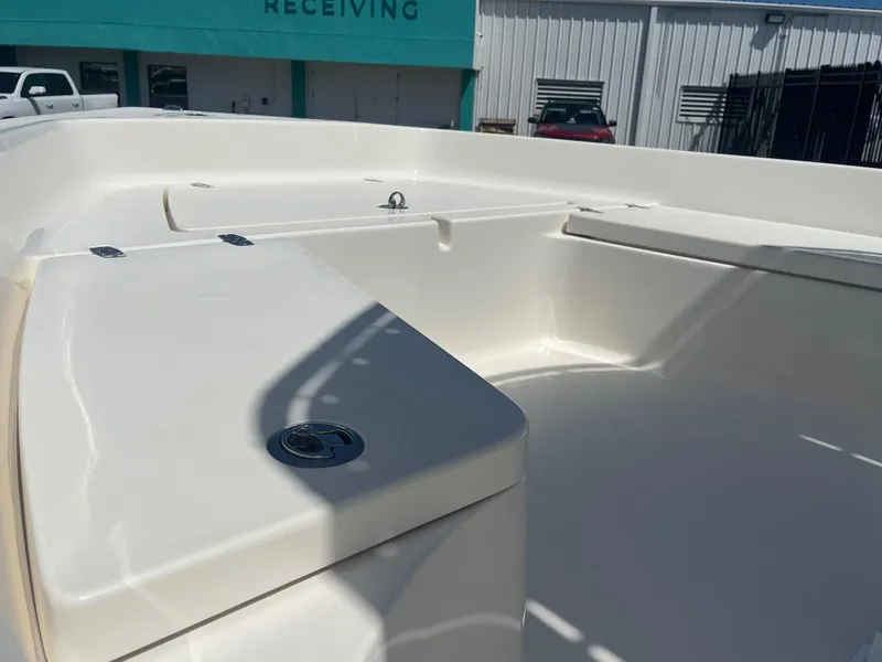 Slide: The Image of 2021 Cobia 21 Bay boat interior with storage compartments, in a marina setting. - 8