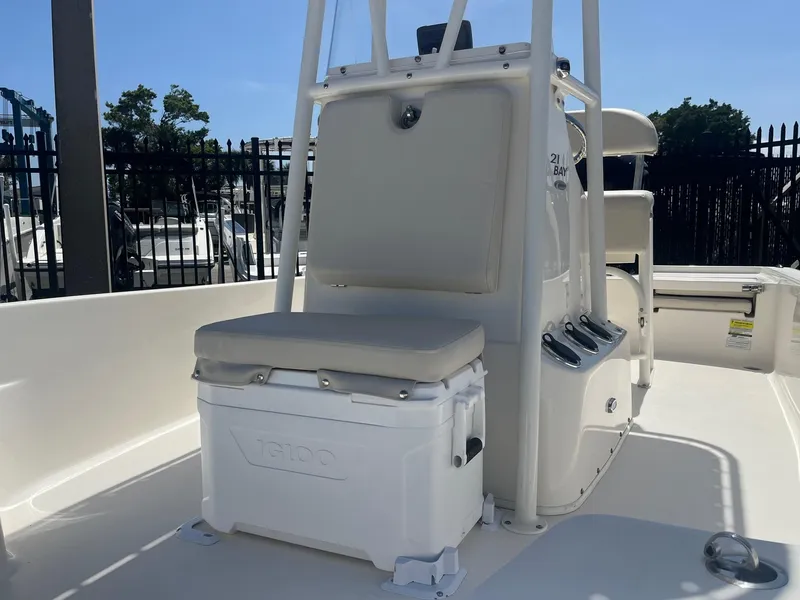 Slide: The Image of 2021 Cobia 21 Bay boat interior with seating and storage, featuring a cooler. - 9