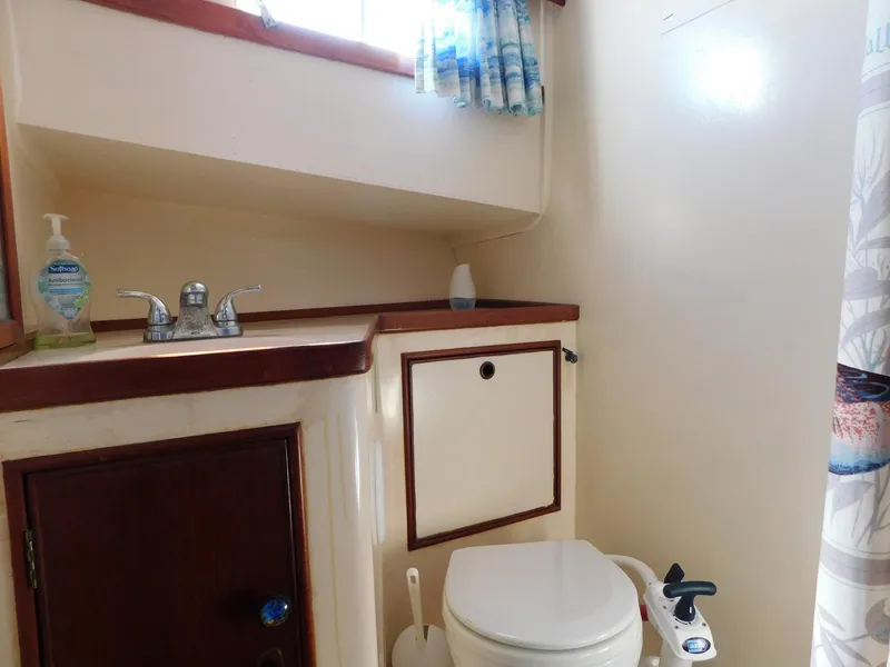Slide: The Image of 1979 Grand Banks 32 Sedan bathroom with sink, toilet, and storage cabinet. - 13