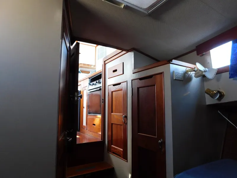Slide: The Image of Interior of 1979 Grand Banks 32 Sedan, featuring wooden cabinetry and compact design. - 14
