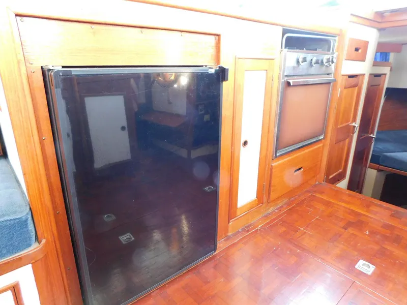 Slide: The Image of 1979 Grand Banks 32 Sedan interior with wood cabinetry and kitchen appliances. - 16