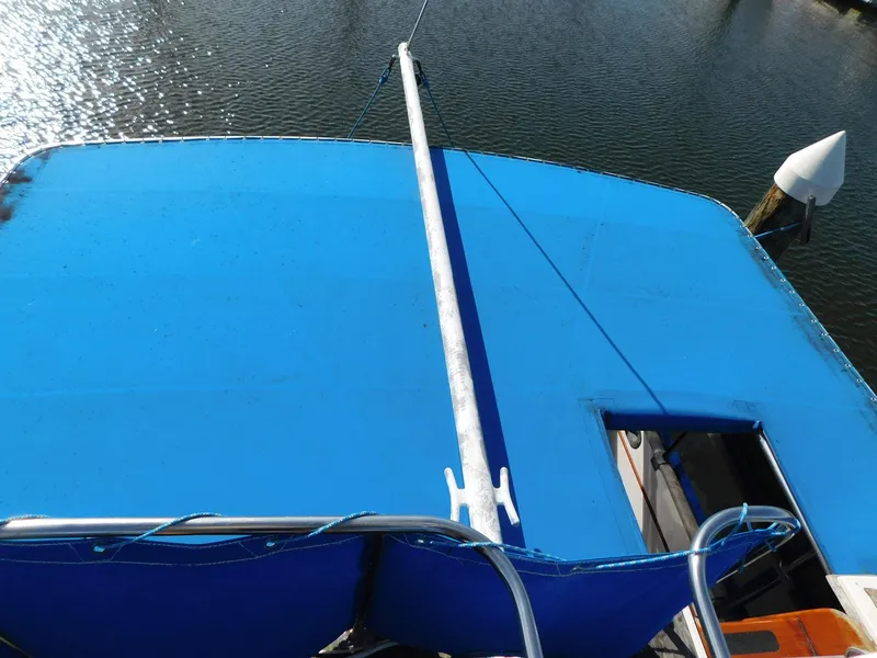 Slide: The Image of 1979 Grand Banks 32 Sedan boat with blue canopy on calm water. - 19