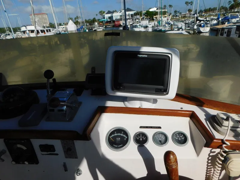 Slide: The Image of 1979 Grand Banks 32 Sedan helm with navigation equipment and marina view. - 22