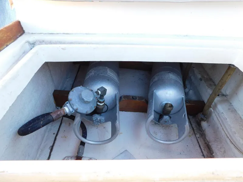 Slide: The Image of 1979 Grand Banks 32 Sedan propane storage compartment with two tanks and regulator. - 24