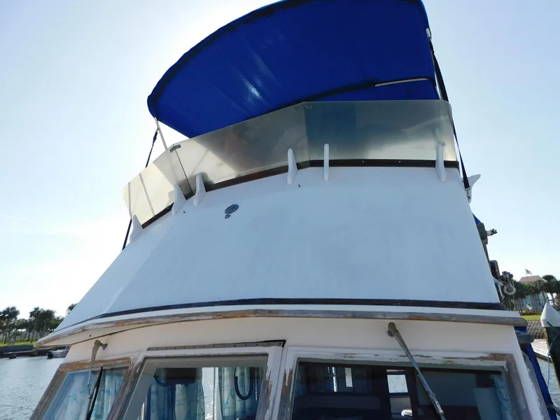 Slide: The Image of 1979 Grand Banks 32 Sedan boat with blue canopy, viewed from the front. - 28