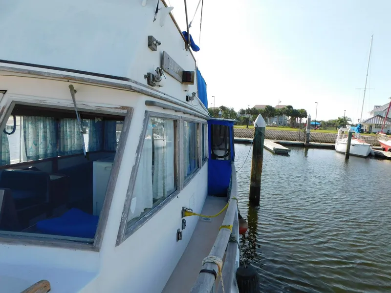Slide: The Image of 1979 Grand Banks 32 Sedan docked at marina, showcasing side view and windows. - 29