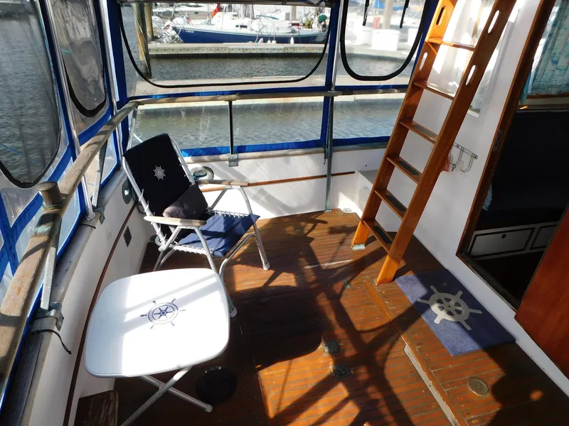 Slide: The Image of 1979 Grand Banks 32 Sedan boat deck with chairs and wooden ladder. - 30
