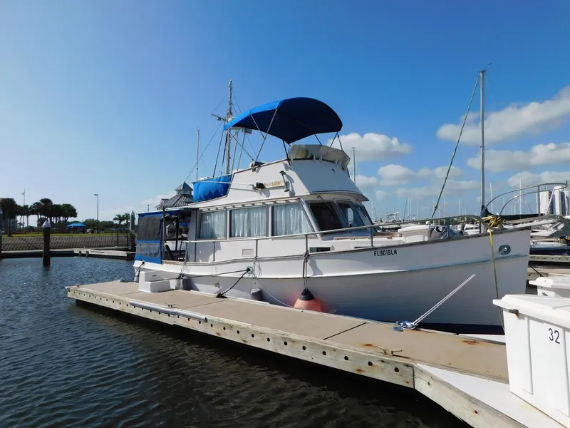 Slide: The Image of 1979 Grand Banks 32 Sedan docked at marina under clear blue sky. - 32