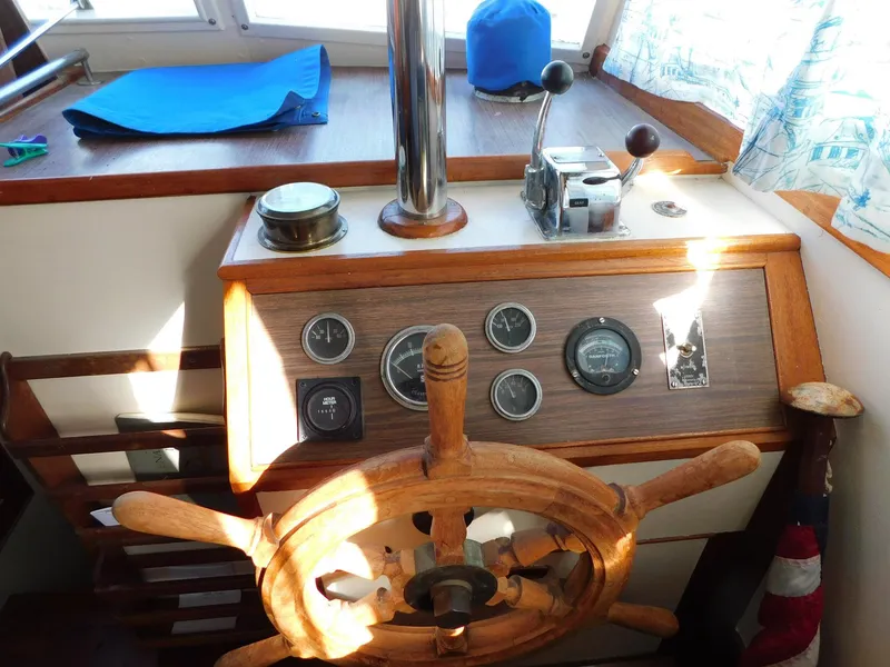 Slide: The Image of 1979 Grand Banks 32 Sedan helm with wooden wheel and vintage gauges. - 5