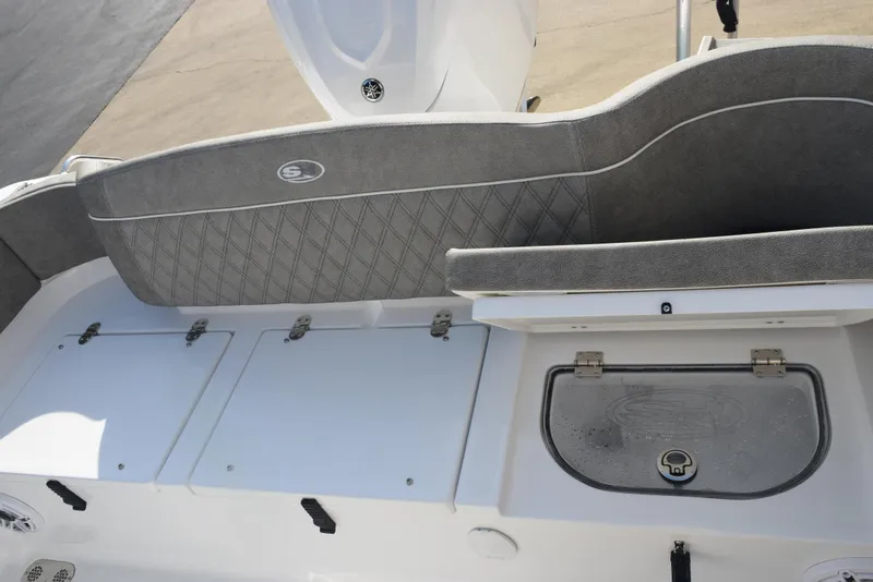 Slide: The Image of 2025 Sea Hunt Ultra 255 SE boat interior with storage compartments and cushioned seating. - 18