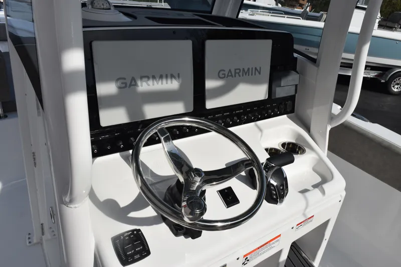 Slide: The Image of 2025 Sea Hunt Ultra 255 SE boat dashboard with Garmin navigation displays. - 9