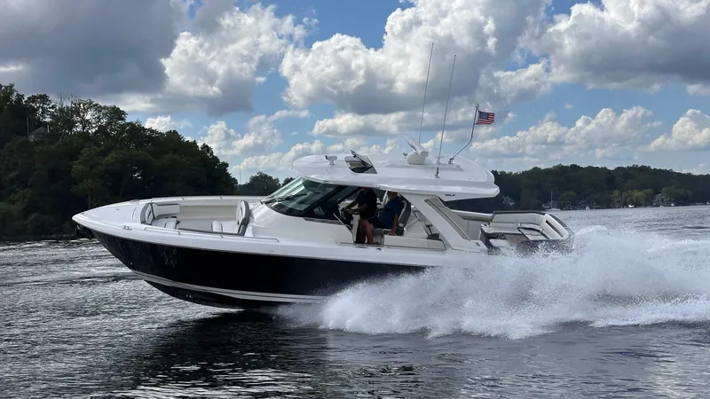 Slide: The Image of 2021 Tiara Yachts 38 LS cruising on a lake under a cloudy sky. - 1
