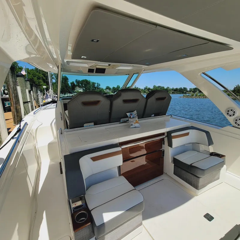 Slide: The Image of 2021 Tiara Yachts 38 LS interior with seating, sleek design, and waterfront view. - 46