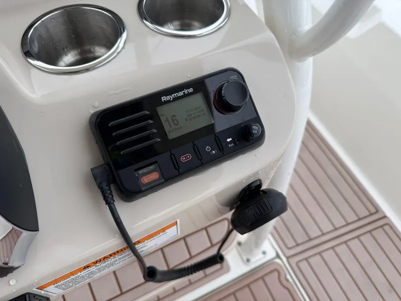 Slide: The Image of Raymarine marine radio on 2022 Boston Whaler 210 Montauk console with cup holders. - 18