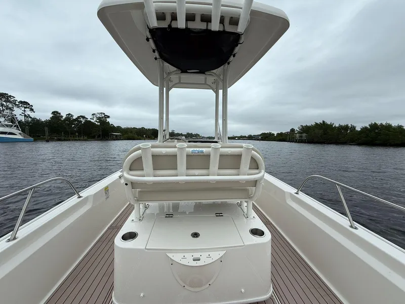 Slide: The Image of 2022 Boston Whaler 210 Montauk boat on a calm river, featuring a center console. - 20