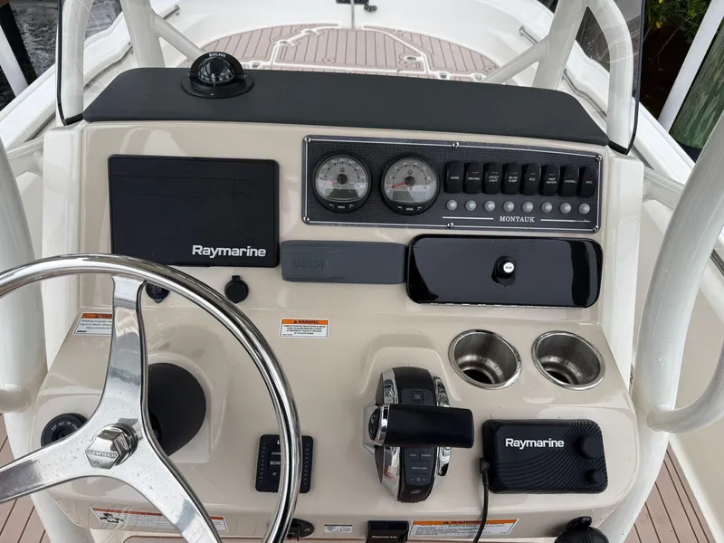 Slide: The Image of 2022 Boston Whaler 210 Montauk dashboard with Raymarine electronics and steering wheel. - 24