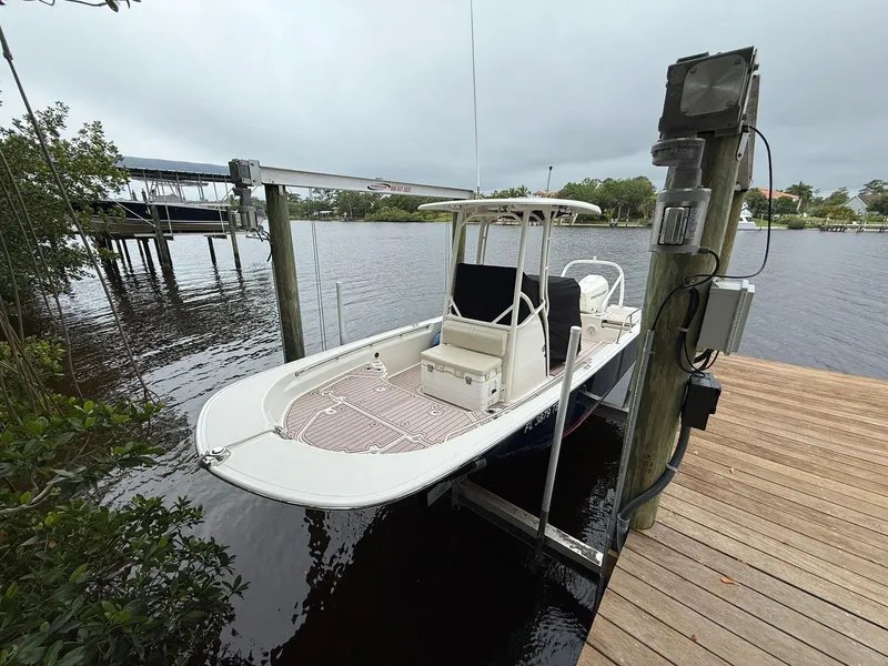 Slide: The Image of 2022 Boston Whaler 210 Montauk boat docked on a lift by a wooden pier. - 26