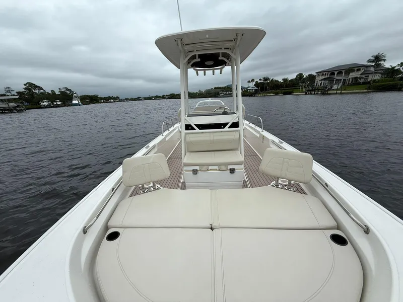 Slide: The Image of 2022 Boston Whaler 210 Montauk boat on calm water, featuring spacious deck and seating. - 6
