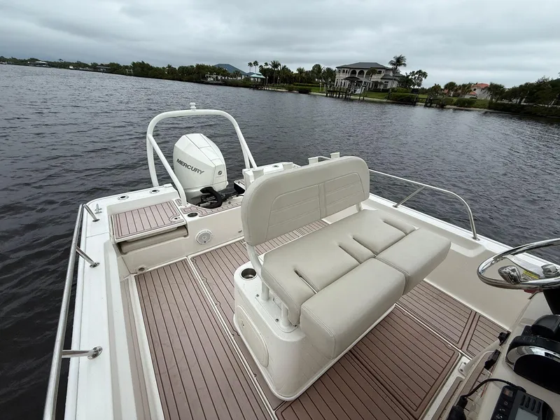Slide: The Image of 2022 Boston Whaler 210 Montauk boat with seating, on a calm lake with overcast skies. - 7