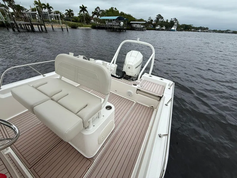 Slide: The Image of 2022 Boston Whaler 210 Montauk boat on calm water, featuring spacious seating and modern design. - 8