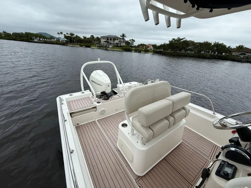Slide: The Image of 2022 Boston Whaler 210 Montauk boat on calm water, featuring spacious seating and modern design. - 9