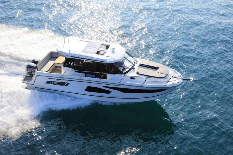 Slide: The Image of 2025 Jeanneau NC1095 Coupe cruising on open water, showcasing sleek design and performance. - 3